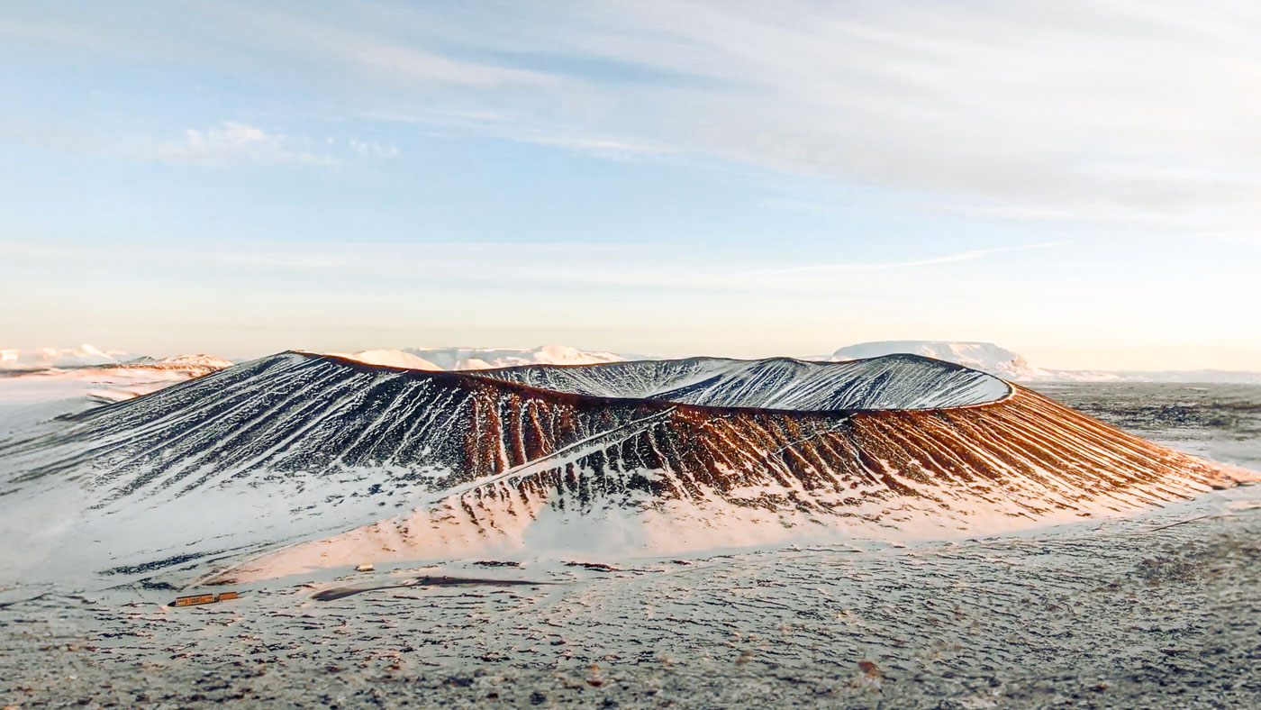 Snow capped volcano crater sunrise.