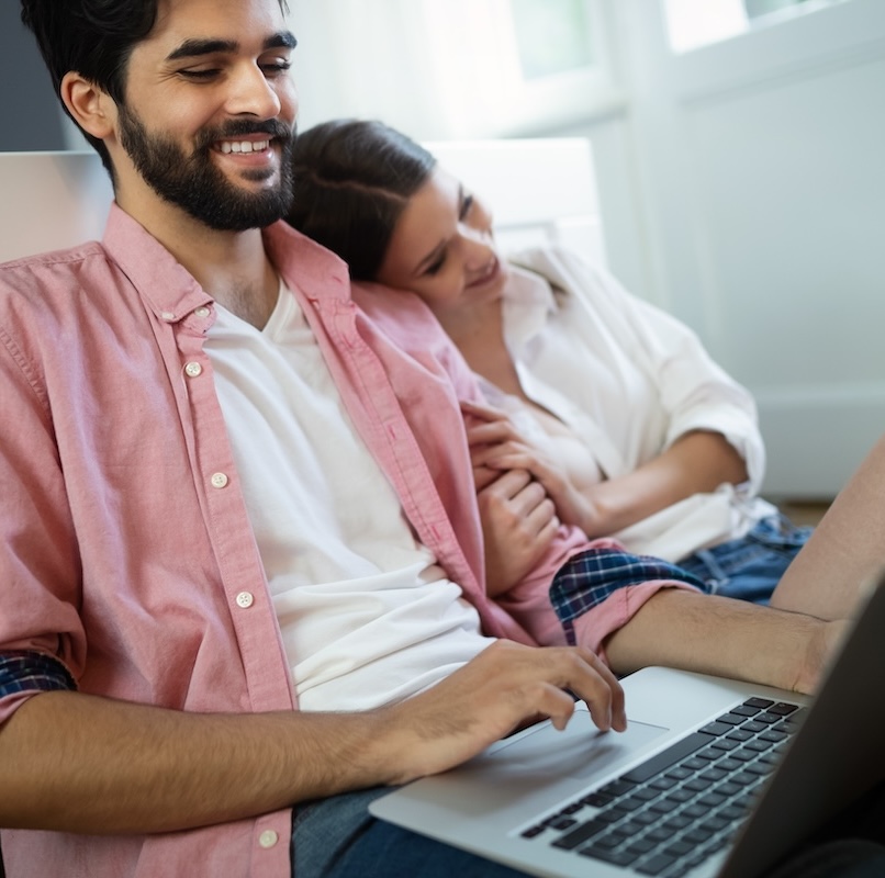 Smiling couple using laptop